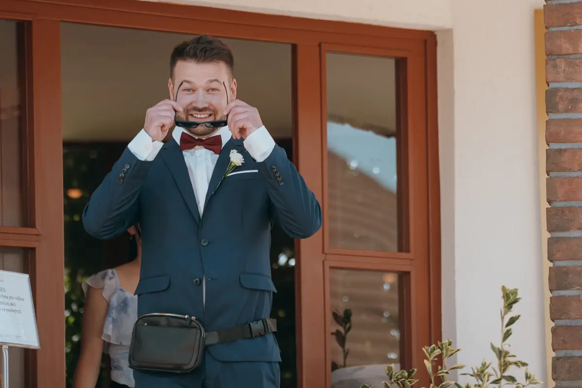 Ženich s úsměvem si nasazuje sluneční brýle