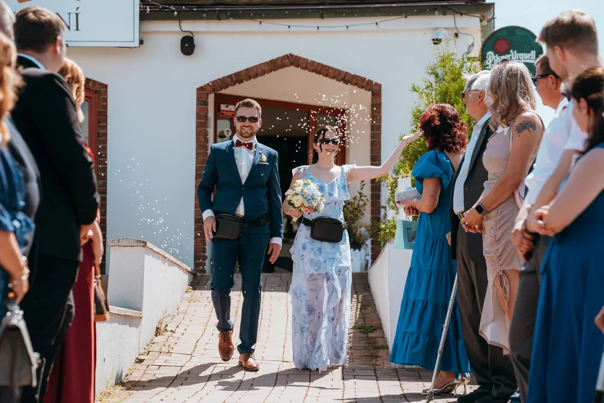 Novomanželé vychází z obřadu – hosté sypou rýži