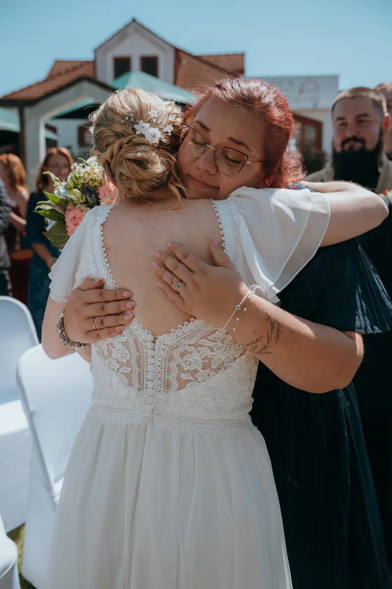Nevěsta v objetí s kamarádkou po obřadu