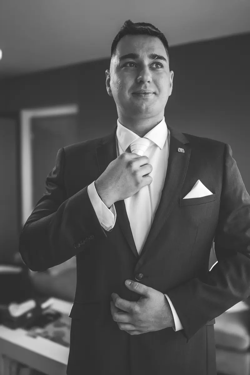 Ženich si upravuje kravatu – černobílá fotografie